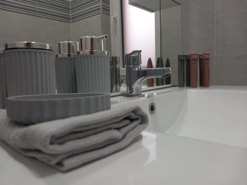 een badkamer met een wastafel, een spiegel en handdoeken bij La Casa di Marta in Corsico