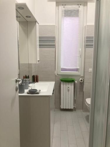 uma casa de banho branca com um lavatório e um WC em La Casa di Marta em Corsico