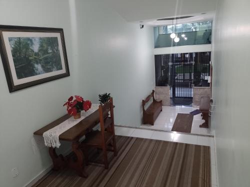 ein Wohnzimmer mit einem Tisch, Stühlen und einem Fenster in der Unterkunft Apartamento para até 05 pessoas no centro in Teresópolis