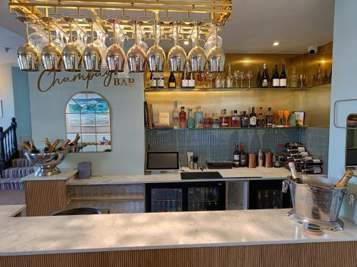 a bar with glasses on the wall and a counter at The Beach Club in Penzance