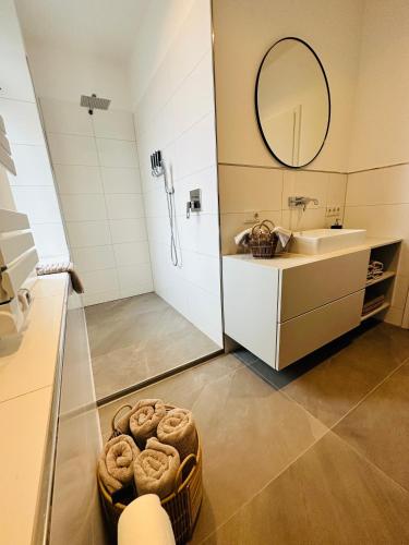 a bathroom with a sink and a shower and a basket of bread at Ferienwohnung Obernkirchen in Obernkirchen