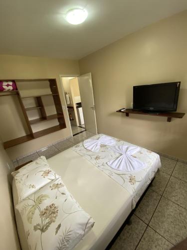 a bedroom with a bed and a flat screen tv at Casa Bouganville in Novo Airão