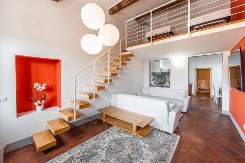 ein Wohnzimmer mit einer weißen Couch und einer Treppe in der Unterkunft Santo Spirito Apartment in Florenz