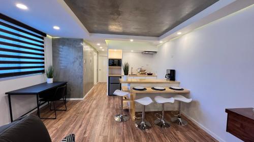 a kitchen with a counter and stools in a room at Baja Suites - Departamentos Vacacionales in Ensenada