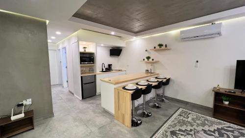 a kitchen with a counter and stools in a room at Baja Suites - Departamentos Vacacionales in Ensenada
