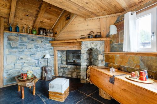 a living room with a stone fireplace in a cabin at Le Hameau de mon Père in Manigod