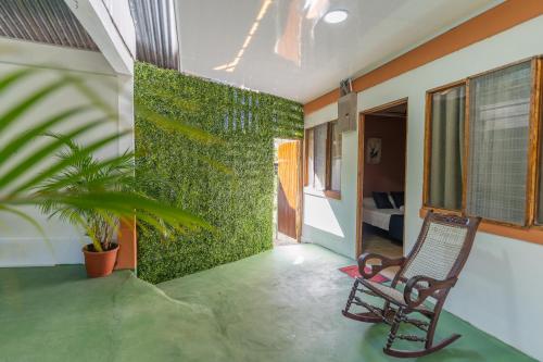 una camera con sedia e parete verde di El Cocobolo Food&Rest Room 4 Bed and Breakfast WiFi AC Pkg gratis a Liberia