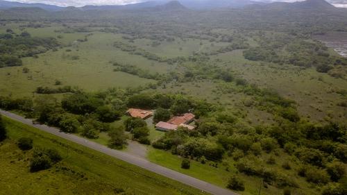 an aerial view of a house in a field next to a road at Hotel El Cocobolo Food&Rest Room 4 B&B WiFi AC Pkg Free Swimmingpool in Liberia