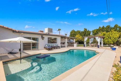 a swimming pool in front of a house at The Sunny Side House in Palm Springs