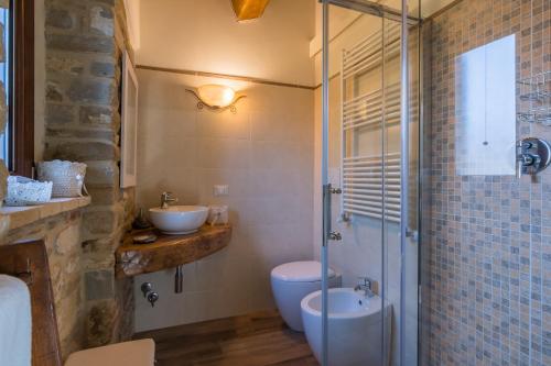 a bathroom with a toilet and a sink and a shower at Agriturismo Fonte Rosa in Fiastra