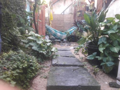 een tuinpad met een hangmat in het midden bij Casa Caiçara de Hospedagem Paraty in Paraty