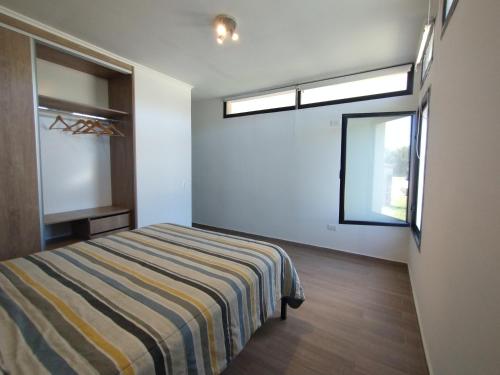 Schlafzimmer mit einem Bett und einem Fenster in der Unterkunft Casas en Barrio Los Teros con pileta compartida - Santa Clara del Mar in Santa Clara del Mar