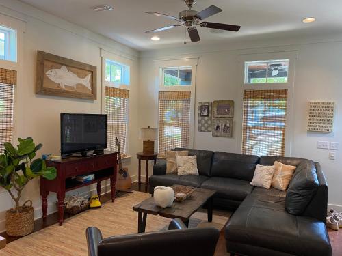 a living room with a couch and a flat screen tv at The Summer Palace in Inlet Beach