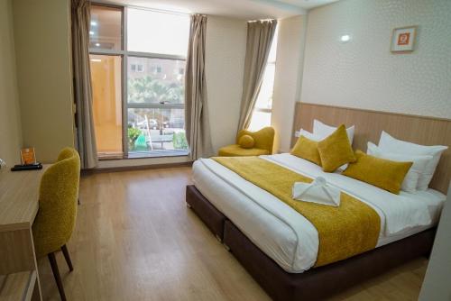 um quarto de hotel com uma cama, uma secretária e uma janela em Sahariano hotel City Center em Laayoune