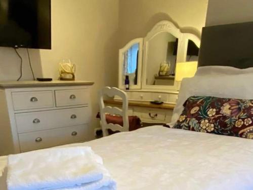 a bedroom with a bed and a dresser with a mirror at Bird In Bush Elsdon in Elsdon