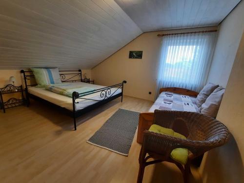 a attic room with a bed and a couch at Blumenschein-Ferienwohnung Obbe in Kirchzell