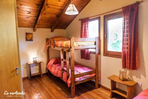 a bedroom with two bunk beds and a window at Cabaña la vertiente in Lago Puelo