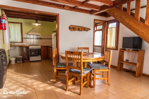 cocina y comedor con mesa y sillas en Cabaña la vertiente en Lago Puelo