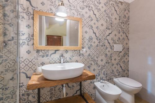 a bathroom with a sink and a toilet and a mirror at Agriturismo Fonte Rosa in Fiastra
