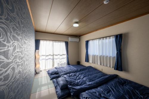 a small bedroom with a bed and a window at VILLENT KUJUKURI MARINE in Kujukuri