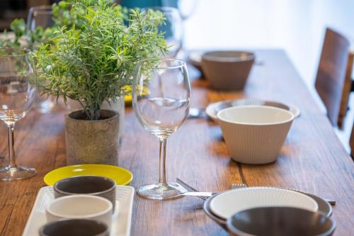 a wooden table with wine glasses and plates and plants at VILLENT KUJUKURI MARINE in Kujukuri