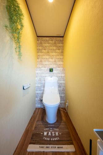 a bathroom with a toilet on a wooden floor at VILLENT KUJUKURI MARINE in Kujukuri