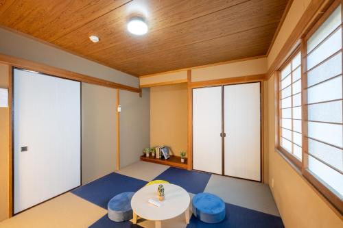 a room with a table and blue stools at VILLENT KUJUKURI MARINE in Kujukuri
