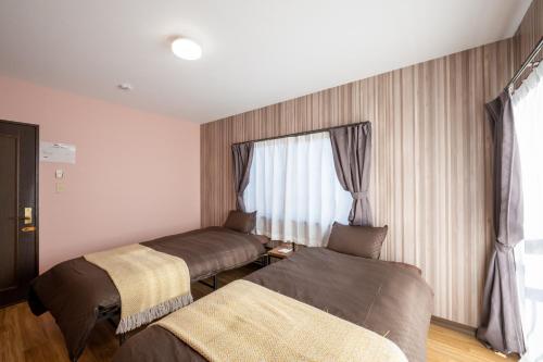 a hotel room with two beds and a window at VILLENT KUJUKURI MARINE in Kujukuri