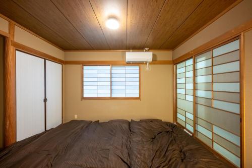 a bedroom with a bed and a window at VILLENT KUJUKURI MARINE in Kujukuri