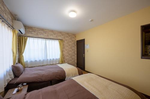 a hotel room with two beds and a window at VILLENT KUJUKURI MARINE in Kujukuri