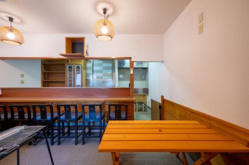 a dining room with wooden tables and blue chairs at VILLENT KUJUKURI MARINE in Kujukuri