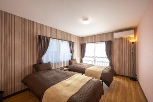 a hotel room with two beds and a window at VILLENT KUJUKURI MARINE in Kujukuri