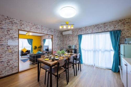 a kitchen and dining room with a table and a brick wall at VILLENT KUJUKURI MARINE in Kujukuri