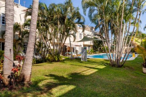 a resort yard with a swimming pool and palm trees at Nuevo en Booking Casa Acapulco Diamante a Pasos de la Playa in Acapulco