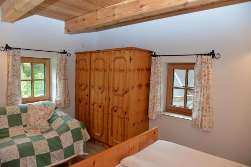 a bedroom with a bed and a wooden cabinet at Ferienhaus Schöberlhütte 