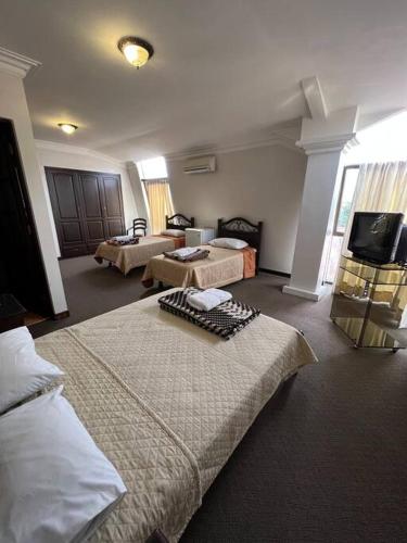 Habitación de hotel con 2 camas y TV de pantalla plana. en Habitación Delegación-Corso 2023, en Cochabamba