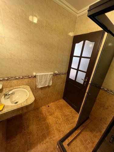 baño con lavabo y puerta con ventana en Habitación Delegación-Corso 2023, en Cochabamba