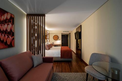 sala de estar con sofá y cama en TURIM Oporto Hotel, en Oporto