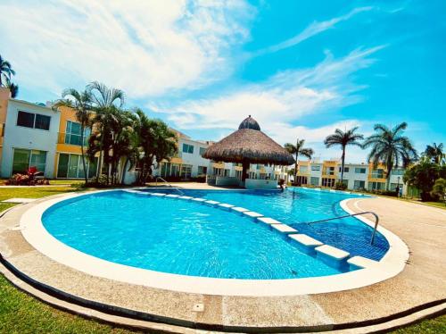 a swimming pool with a gazebo next to a building at NUEVO EN BOOKING CASA TERRANIUM ACAPULCO DIAMANTE in Acapulco