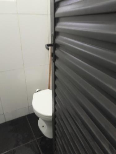 uma casa de banho com um WC e uma porta em Kitnet Rafael em São Thomé das Letras