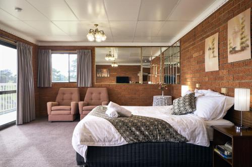 a bedroom with a large bed and a brick wall at The Waterloo Hotel in Swansea