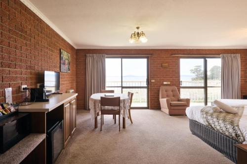 a hotel room with a dining table and a bedroom at The Waterloo Hotel in Swansea