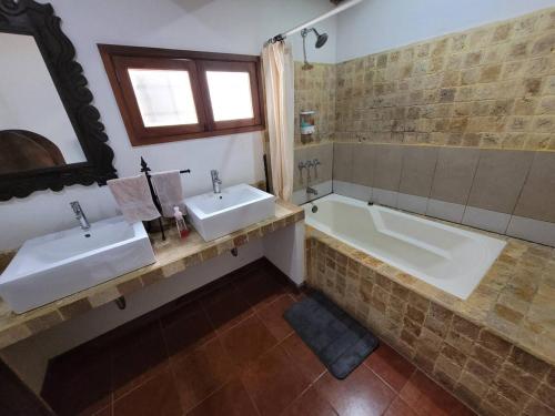 a bathroom with two sinks and a bath tub at Amplia casa Antigua Guatemala con pérgola y jardín in Antigua Guatemala
