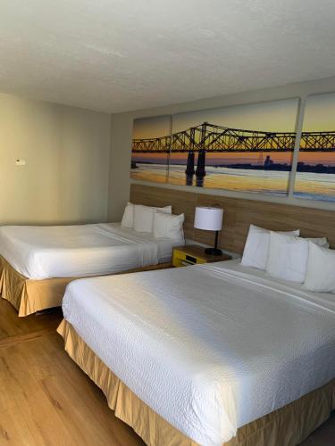 two beds in a hotel room with a bridge at Days Inn by Wyndham Louisville Airport Fair and Expo Center in Louisville