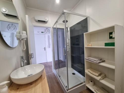 a bathroom with a glass shower and a white sink at Family Surf Home - Casa do Sol in Mafra