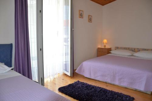 プリモシュテンにあるApartman Burica PRIMOŠTENのベッドが2つと大きな窓がある寝室