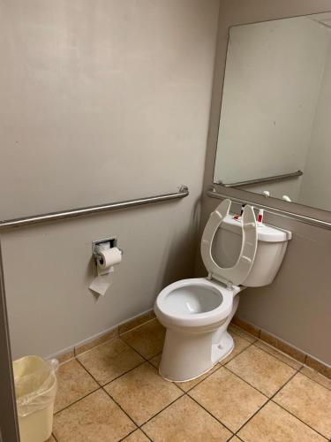 a bathroom with a white toilet and a mirror at Days Inn by Wyndham Louisville Airport Fair and Expo Center in Louisville
