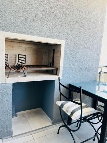 two chairs and a table in a room with a desk at DEPARTAMENTO DE 1 DORMITORIO CON VISTA A LAS SIERRAS Av Colon 5034 in Cordoba