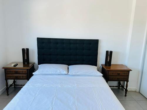a bedroom with a bed with two night tables at DEPARTAMENTO DE 1 DORMITORIO CON VISTA A LAS SIERRAS Av Colon 5034 in Cordoba