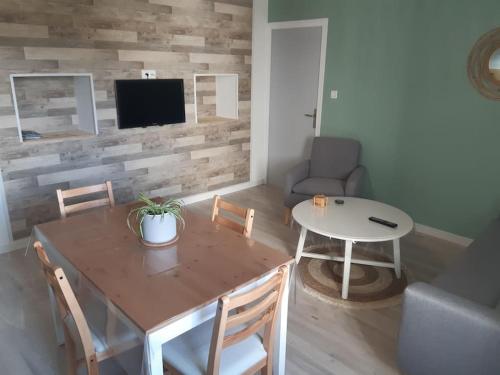 sala de estar con mesa y comedor en Maisonnette avec jardin 